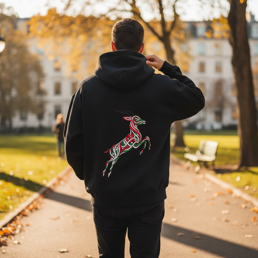 Ghazal Zip Hoodie: black zip-up hoodie with a leaping gazelle embroidered in red, green and white